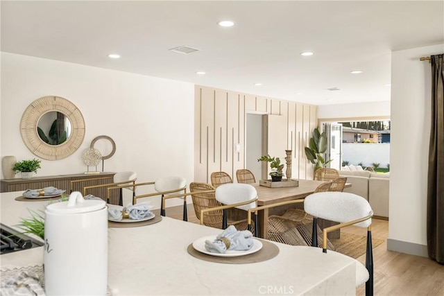 dining room with recessed lighting, light wood-style flooring, and baseboards