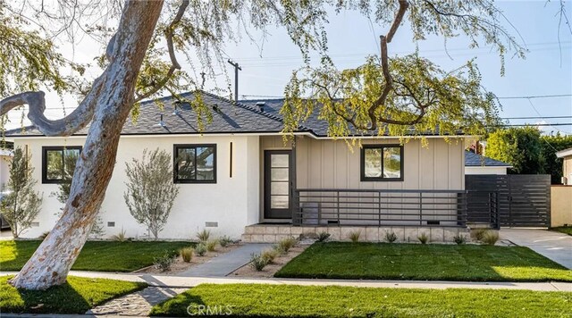 view of front of property featuring a shingled roof, a front yard, crawl space, and fence