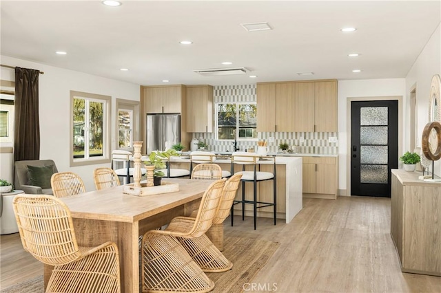 dining area with light wood-style floors and recessed lighting