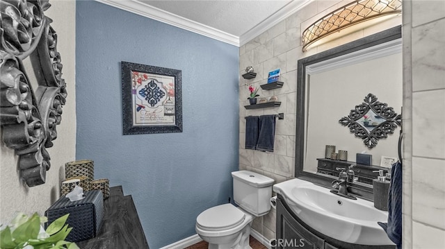 bathroom featuring a textured ceiling, toilet, vanity, and ornamental molding