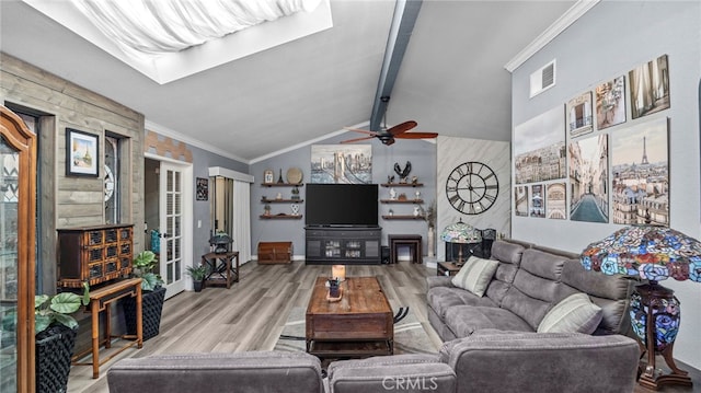 living room with ceiling fan, french doors, vaulted ceiling with beams, crown molding, and light hardwood / wood-style flooring