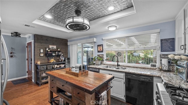 kitchen featuring dishwasher, sink, crown molding, white cabinets, and light stone counters