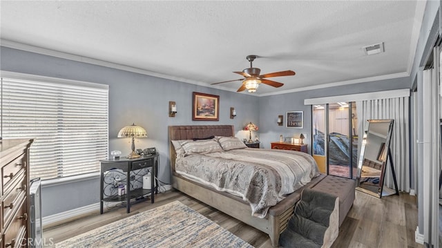 bedroom featuring ceiling fan, a textured ceiling, hardwood / wood-style flooring, and crown molding