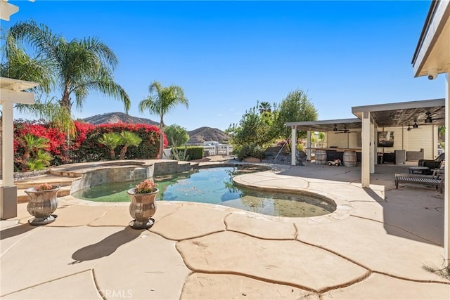 view of swimming pool with an in ground hot tub, a patio area, a mountain view, and ceiling fan