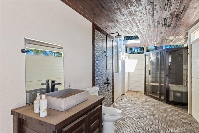 bathroom with toilet, vanity, wooden walls, a shower with shower door, and wooden ceiling