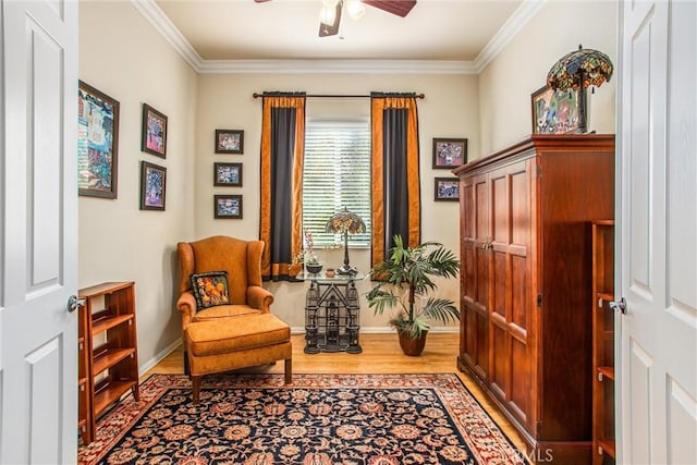 living area with ceiling fan, crown molding, and wood-type flooring