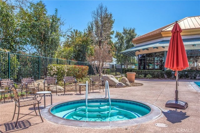 view of pool with a hot tub and a patio