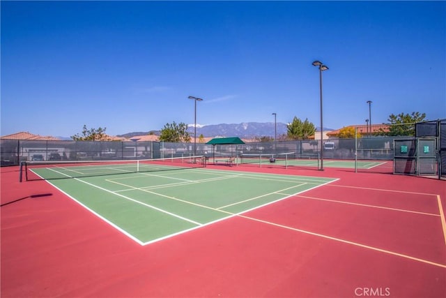 view of tennis court featuring a mountain view and basketball court