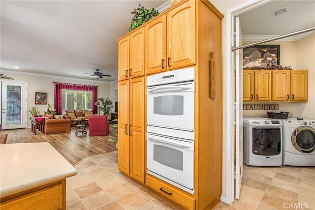 kitchen with white double oven, ceiling fan, crown molding, and washing machine and dryer