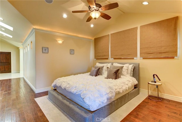 bedroom featuring ceiling fan, wood-type flooring, and lofted ceiling with skylight