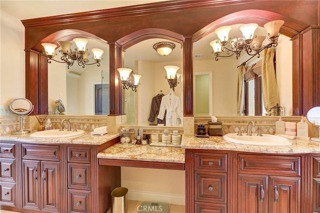 bathroom with backsplash, vanity, and a notable chandelier