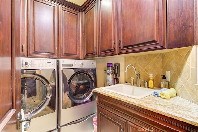 washroom with independent washer and dryer, sink, and cabinets