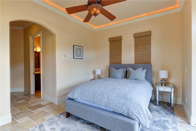 bedroom with ceiling fan, connected bathroom, and ornamental molding