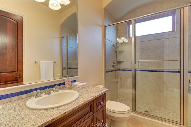 bathroom featuring toilet, a shower with door, and vanity