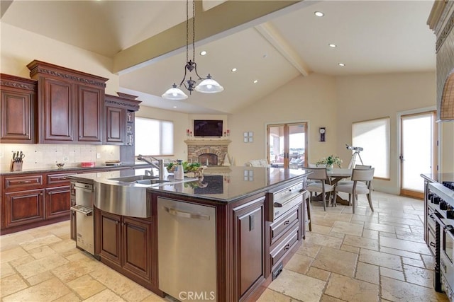 kitchen featuring stainless steel dishwasher, beam ceiling, decorative backsplash, a kitchen island with sink, and a stone fireplace