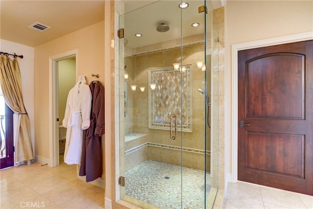 bathroom with a shower with shower door and tile patterned flooring