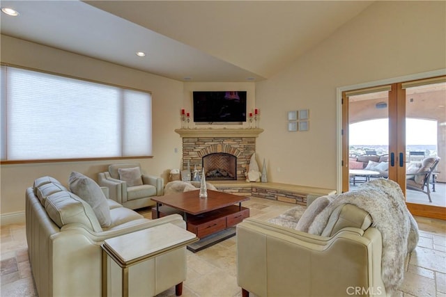 living room with lofted ceiling, a fireplace, and french doors