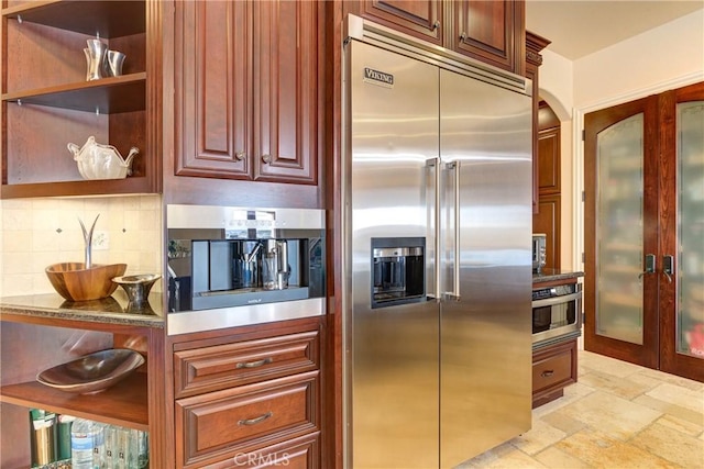 kitchen featuring decorative backsplash, stone countertops, and stainless steel appliances