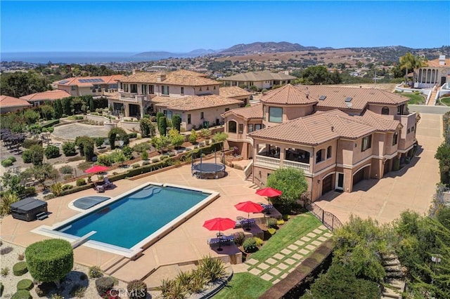 view of swimming pool with a mountain view, a diving board, and a patio