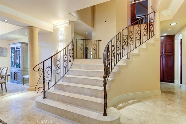 stairway featuring ornamental molding and ornate columns