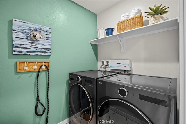 clothes washing area featuring washer and clothes dryer and tile patterned floors