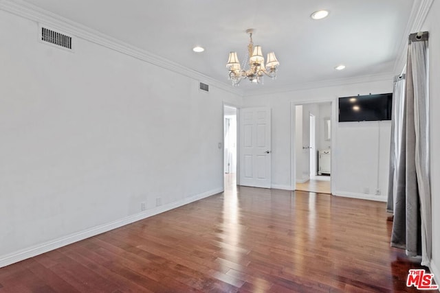 unfurnished living room with a notable chandelier, dark hardwood / wood-style flooring, and ornamental molding