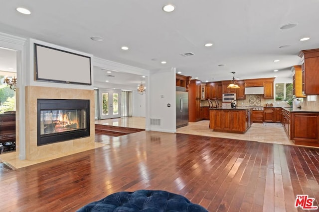 living room with sink, light wood-type flooring, and a healthy amount of sunlight