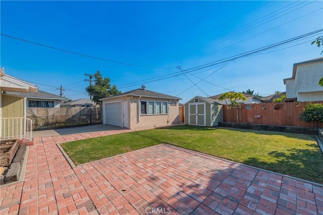 rear view of house with a garage, a patio, a lawn, and a shed