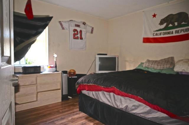 bedroom with dark hardwood / wood-style flooring