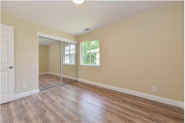 unfurnished bedroom featuring a closet and wood-type flooring