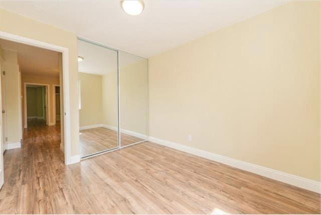 unfurnished bedroom featuring wood-type flooring and a closet