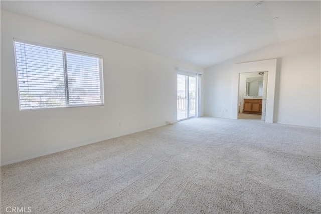 unfurnished living room featuring vaulted ceiling and carpet flooring