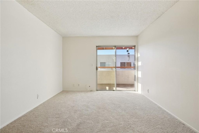 spare room with carpet and a textured ceiling