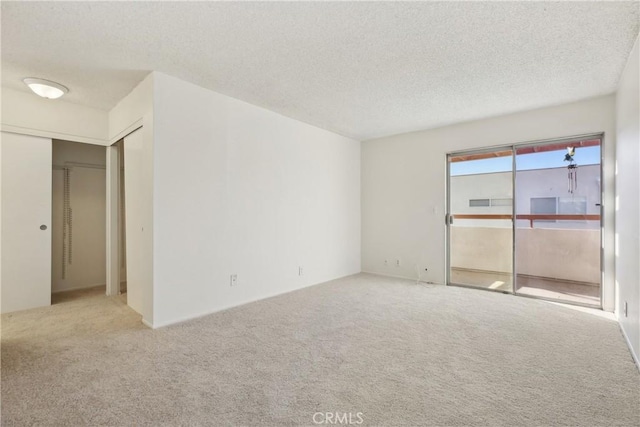 unfurnished room featuring light carpet and a textured ceiling