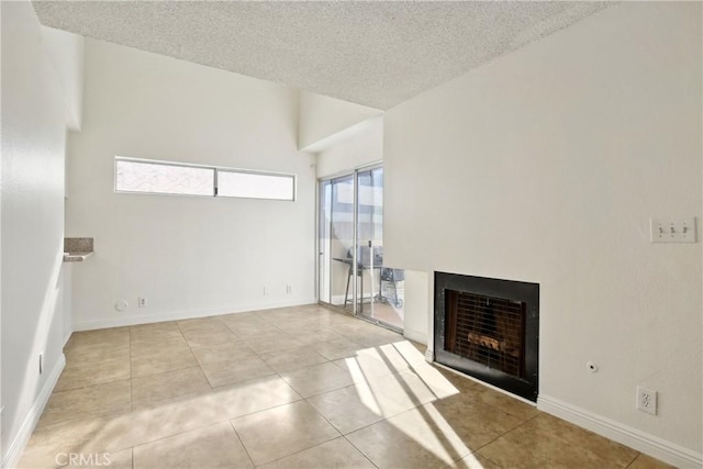 unfurnished living room featuring light tile patterned flooring and a textured ceiling