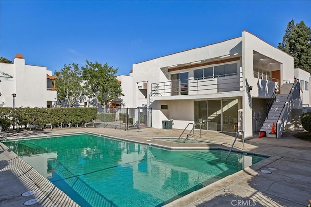 view of swimming pool featuring a hot tub and a patio