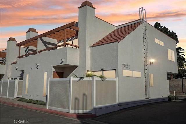 property exterior at dusk with a balcony