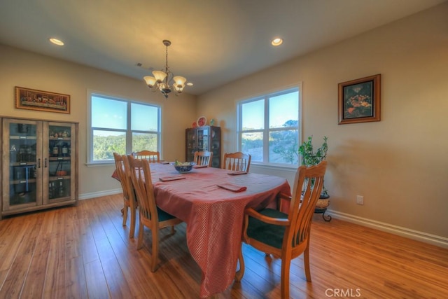 dining room with an inviting chandelier and light hardwood / wood-style flooring