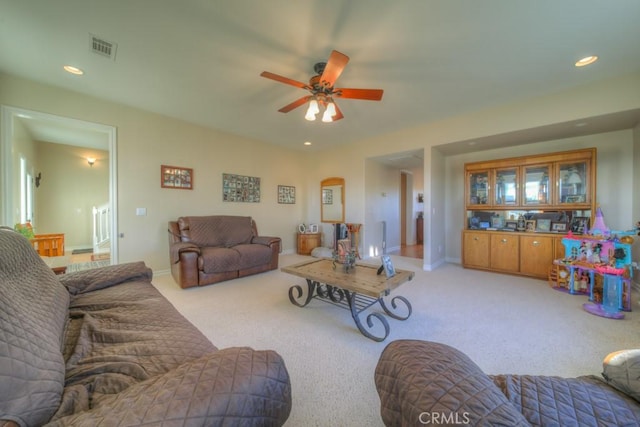 living room with ceiling fan and light colored carpet