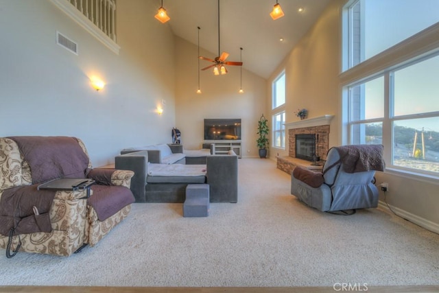 living room featuring a towering ceiling, carpet, and a stone fireplace