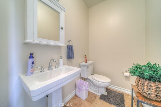 bathroom with sink, toilet, and tile patterned flooring