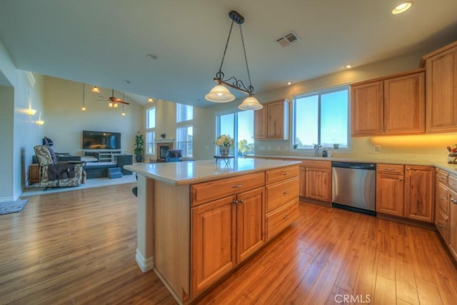 kitchen with decorative light fixtures, light hardwood / wood-style floors, stainless steel dishwasher, a kitchen island, and sink