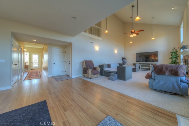 living room featuring light hardwood / wood-style floors and high vaulted ceiling