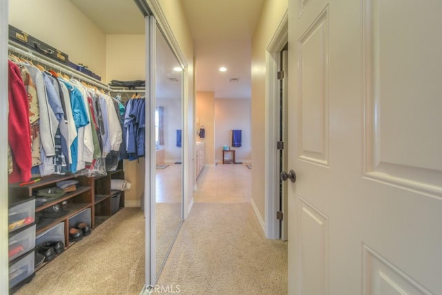 spacious closet featuring light carpet