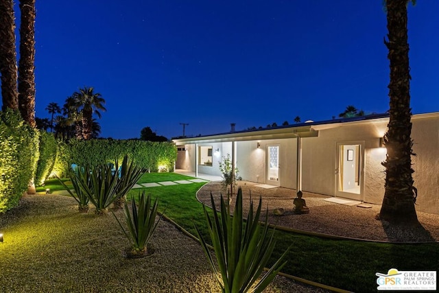 back house at night with a yard