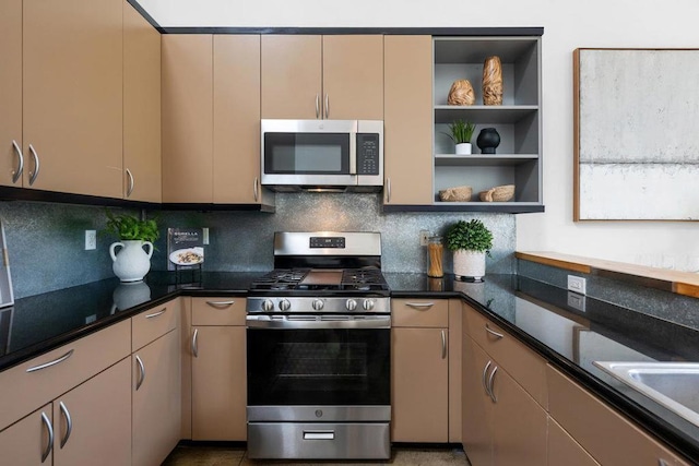 kitchen featuring backsplash, appliances with stainless steel finishes, and dark stone countertops