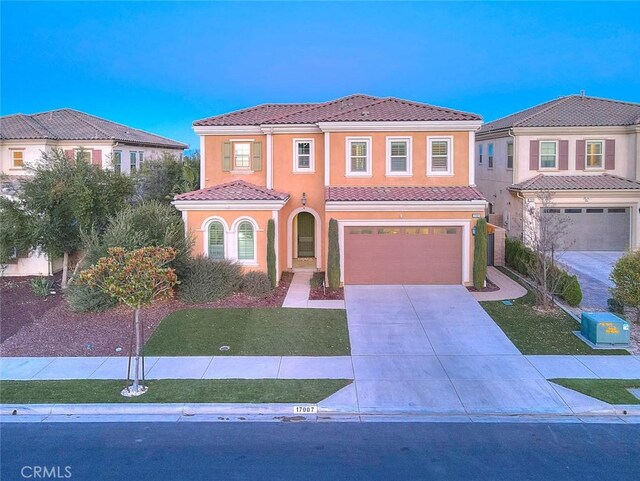 mediterranean / spanish-style home with a front lawn and a garage