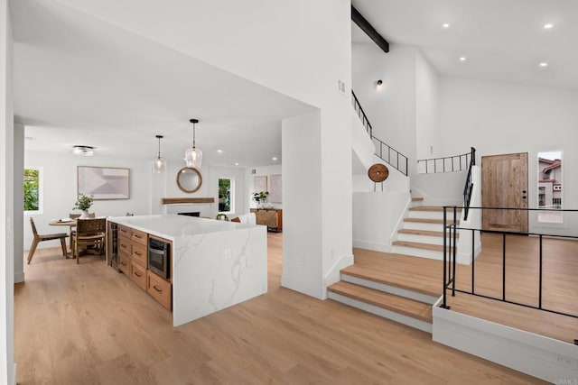 kitchen featuring decorative light fixtures, plenty of natural light, beamed ceiling, and a center island