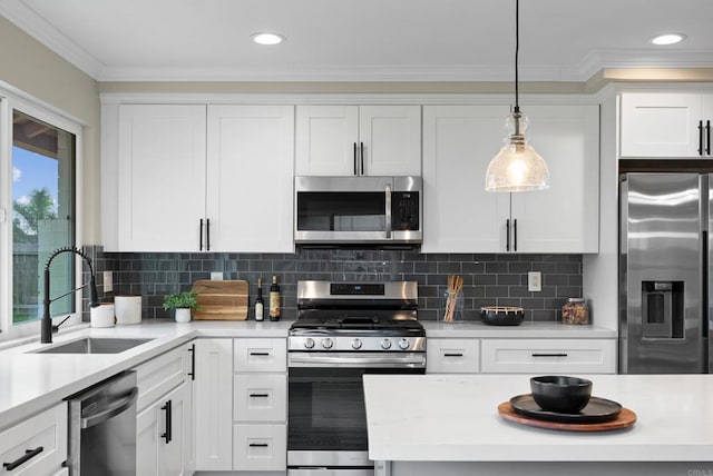 kitchen with appliances with stainless steel finishes, white cabinets, decorative light fixtures, sink, and backsplash