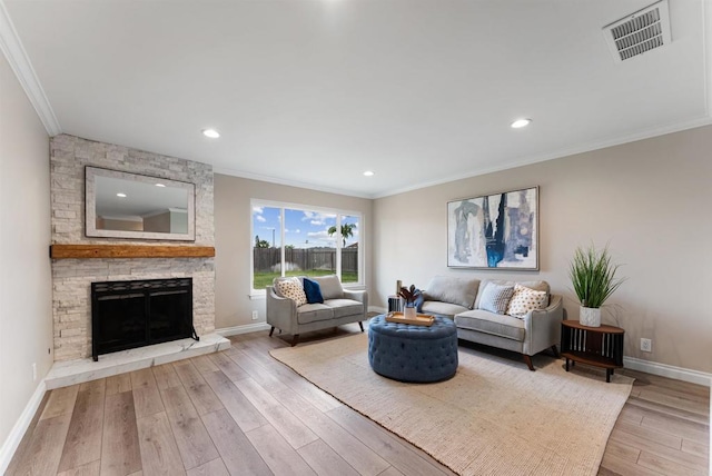 living room with a fireplace, crown molding, and light wood-type flooring